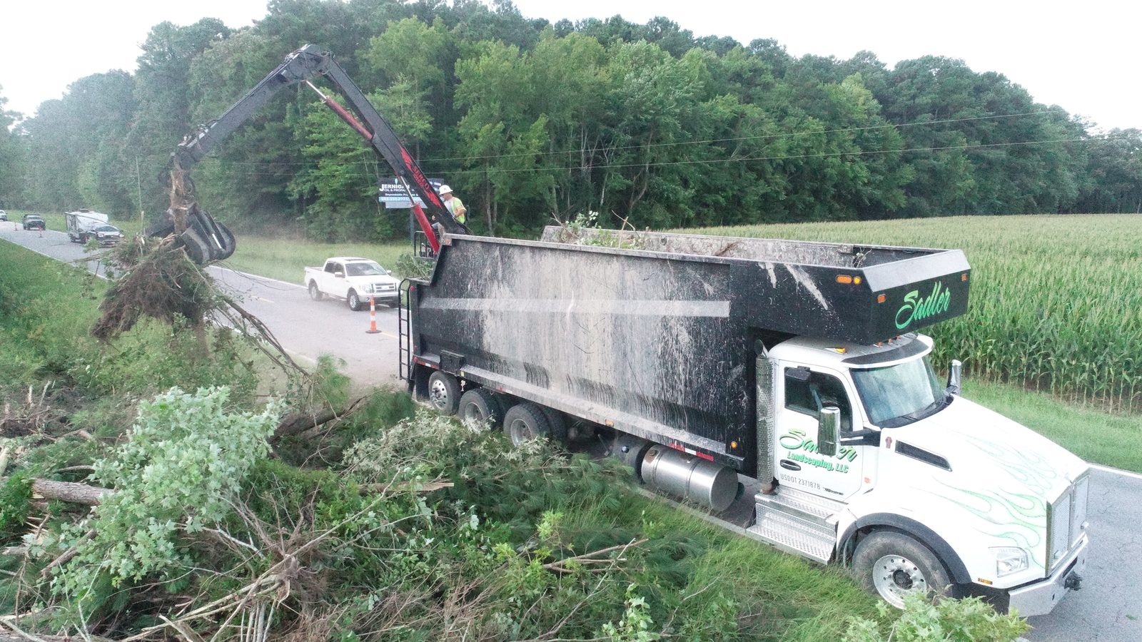 Sadler Landscaping loader truck removing cleared trees and debris